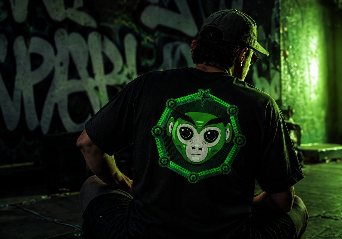 Homem sentado de costas em cenário urbano com grafite, vestindo camiseta Space Chimp com estampa nas costas